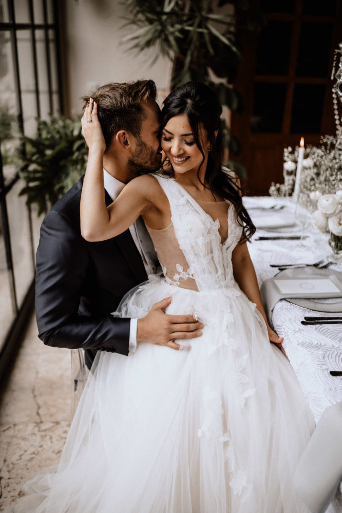Hochzeitsfotografie Morrhof - Ein Hochzeitspaar, dass sich am Tisch auf dem Schoß sitzt
